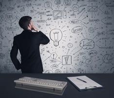 An intelligent office worker drawing strategy ideas and future plan keywords on wall at a brainstorming meeting in office concept